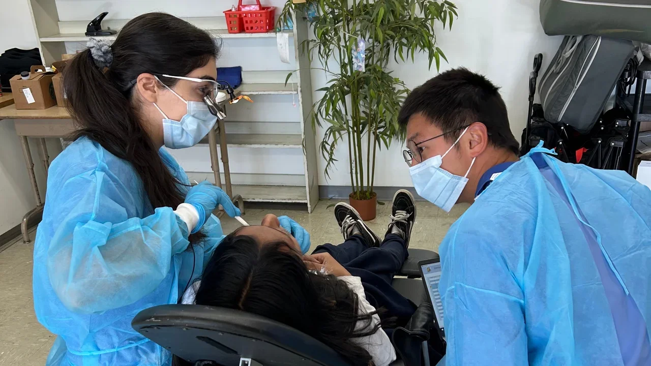 two dental students treating a patient
