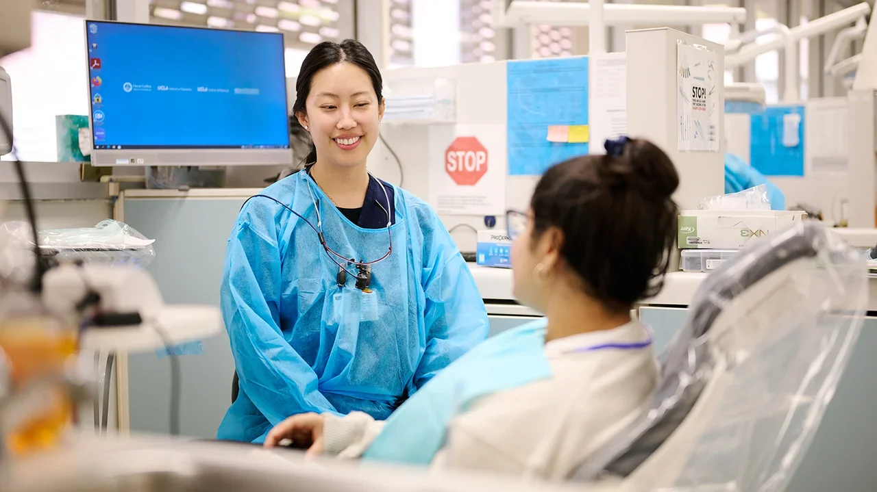 An Advanced Education in General Dentistry (AEGD) resident is speaking with her patient in the clinic.