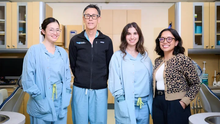 Three dentists in hospital scrubs, along with a social worker wearing leopard-print top