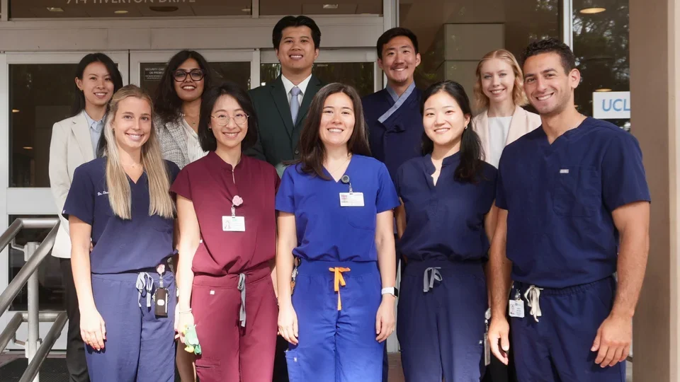 Group of 12 people in dental scrubs, standing on steps