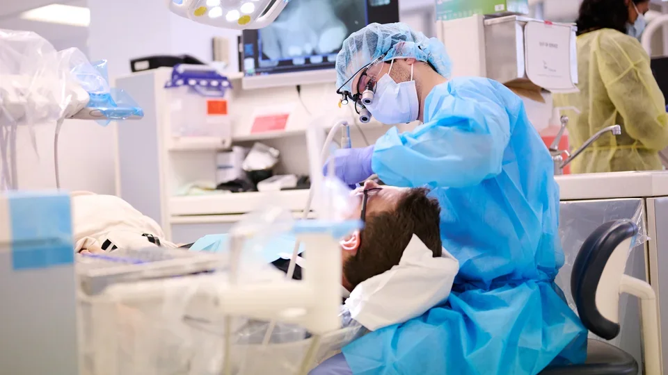 A dental student is operating on a patient.