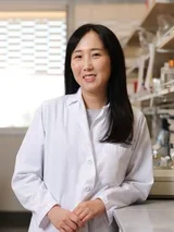 Dr. Insoon Chang in laboratory wearing a lab coat, highlighting scientific research and innovation in oral health.