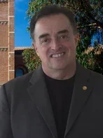 Dr. Ramos wearing a grey coat, and a UCLA building background
