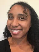 Kharifa Tan wearing a black shirt a off white background