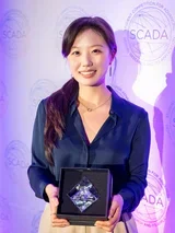 Dr. Soomin Park holding an award from SCADA