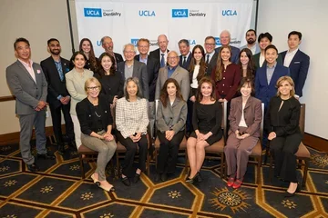 Large group of people in front of UCLA Dentistry backdrop