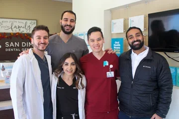 Five dental practitioners posing and smiling