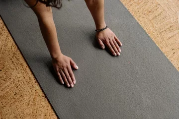 female hands touching a yoga mat