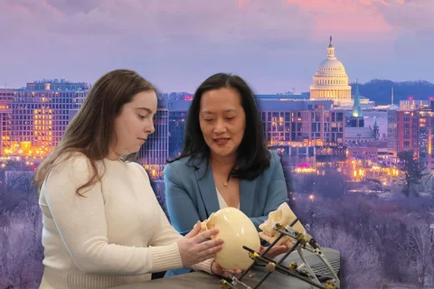 Amy Banks and Janice Lee reviewing craniofacial model with U.S. Capitol in background.