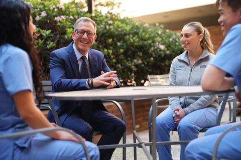 UCLA School of Dentistry Dean Paul Krebsbach speaking with dental students outdoors on campus, highlighting mentorship and leadership in dental education.