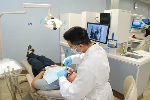 Student dentist in a clinic working on a patient