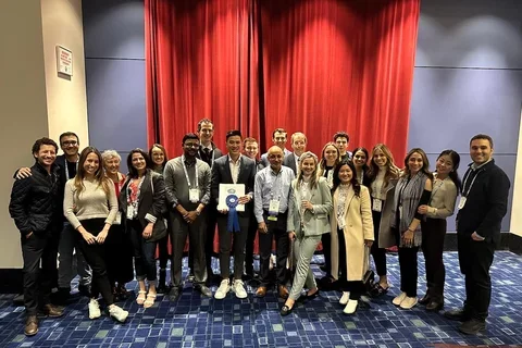 Group photo, with person at center holding an award