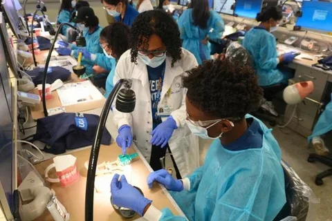 dentist instructing a high school student in the simulation lab