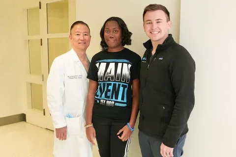 three people posing in a medical center