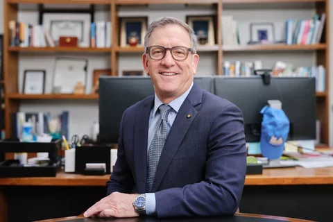 Paul Krebsbach in navy suit, seated at a desk