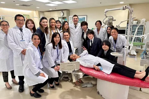 Group in lab coats, posing in a dental clinic