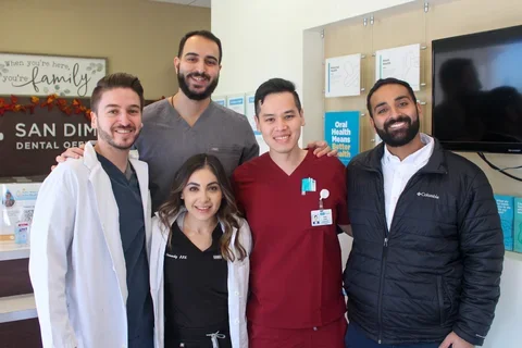 Five dental practitioners posing and smiling