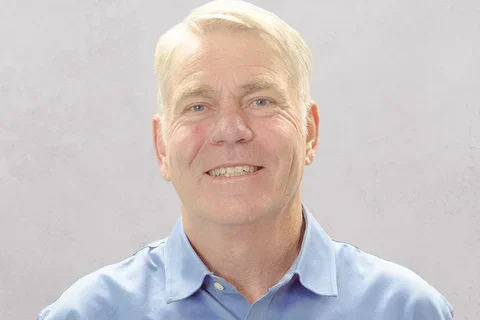 Dr. White is wearing a light blue button-up shirt with a collar.