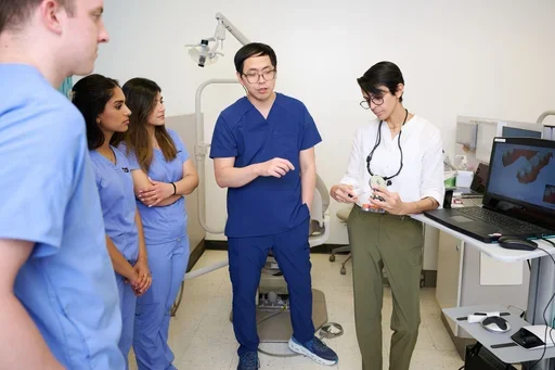Dental instructors demonstrating clinical techniques to UCLA students in a training room, highlighting hands-on dental education and technology.Dental instructor demonstrating clinical techniques to UCLA students in a training room, highlighting hands-on dental education and technology.