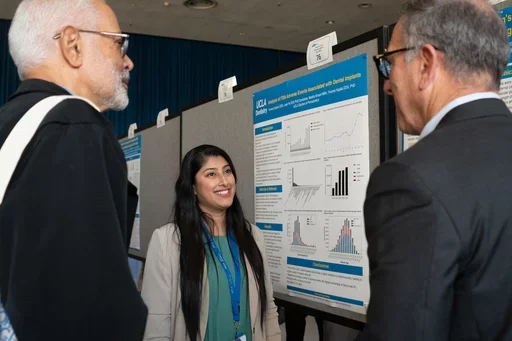 Female researcher explains findings to two men