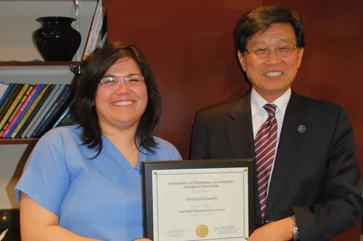 Two people smiling and holding a plaque