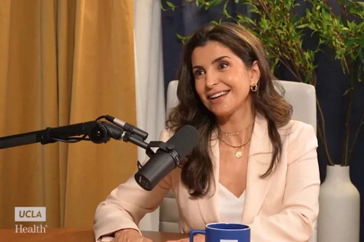 Rana Al Rasheed sitting in front of mic, smiling