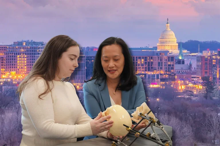 Amy Banks and Janice Lee reviewing craniofacial model with U.S. Capitol in background.