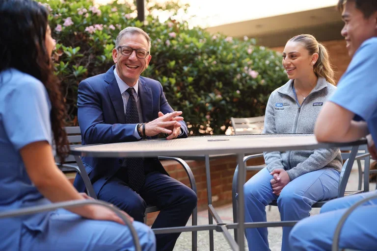 UCLA School of Dentistry Dean Paul Krebsbach speaking with dental students outdoors on campus, highlighting mentorship and leadership in dental education.