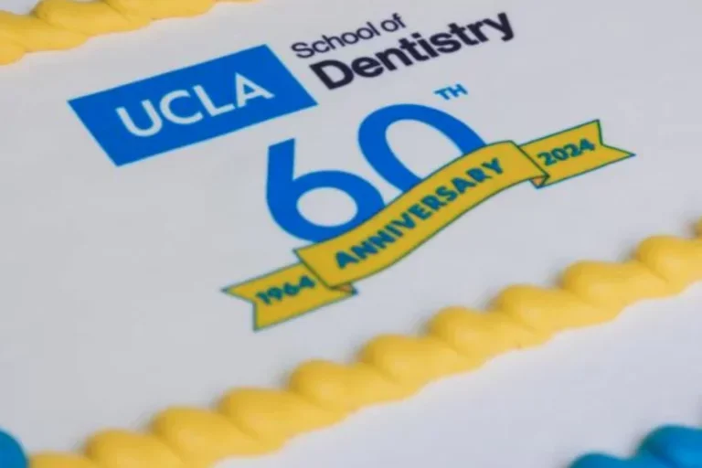 A blue, yellow, and white cake with the text "UCLA School of Dentistry 60th Anniversary 1964-2024"