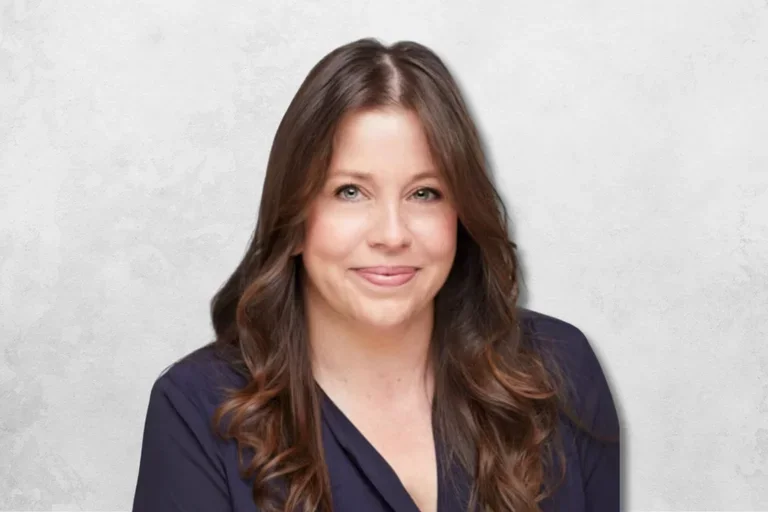Amy Lassere wearing a navy blouse against a light gray backdrop