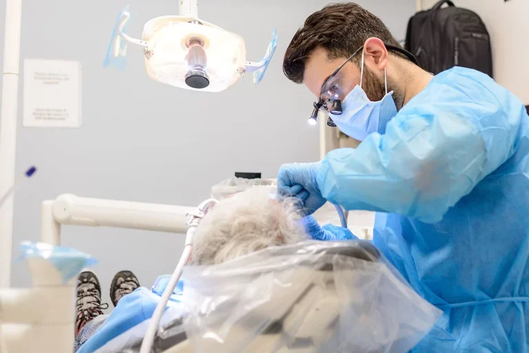Dental student performing care on an elderly patient