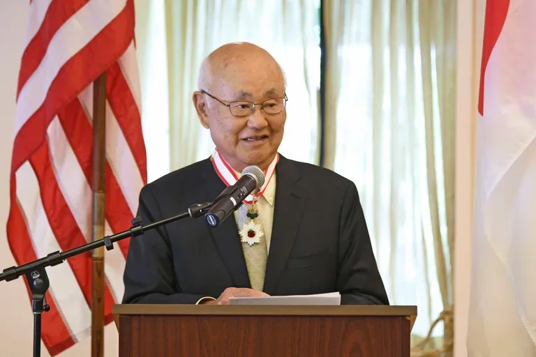 Dr. Henry Takei speaking at a podium
