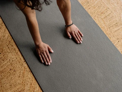 female hands touching a yoga mat