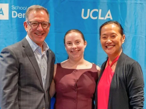 Paul Krebsbach, Amy Banks, and Janice Lee posing together at an academic event in front of blue UCLA Dentistry backdrop