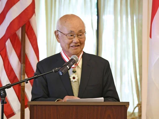 Dr. Henry Takei speaking at a podium