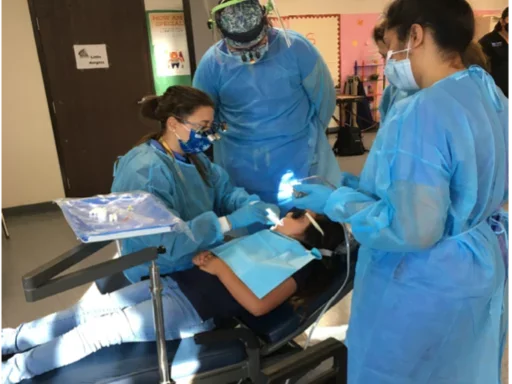 three dental practitioners treating a young patient