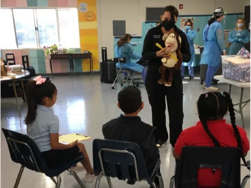 Dentist explaining oral health to children using a stuffed animal