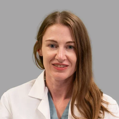 Heather Chiurazzi, smiling, against gray background.