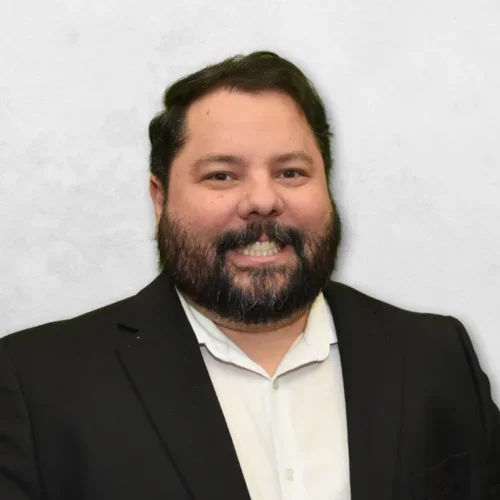 Dr. Radiac is wearing a black suit jacket over a white shirt.