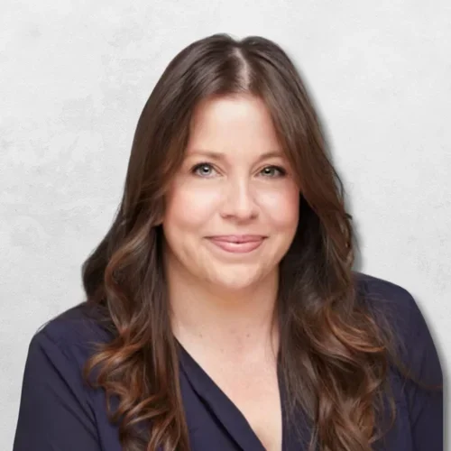 Amy Lassere wearing a navy blouse against a light gray backdrop