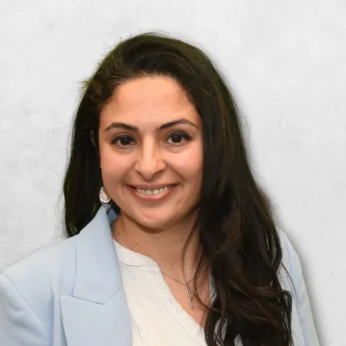 Ayleen R. Peterson is wearing a light blue blazer and has long dark brown hair.