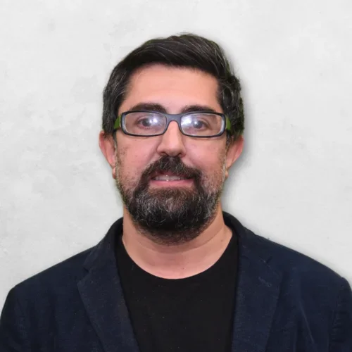 Seyed Hossein Beheshti is wearing a blue blazer over a black shrit and has glasses.
