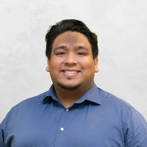 Daniel Castillo is wearing a medium blue button-up shirt.