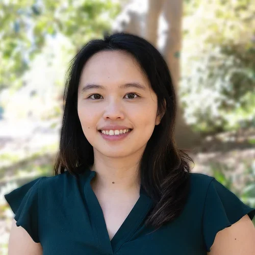 Dr. Chiam is in an out setting wearing a short sleeve dark green blouse.