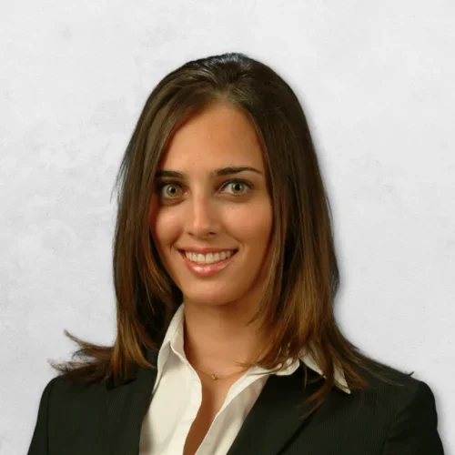 Dr. Termeie has long brown hair and is wearing a black blazer with a white shirt.