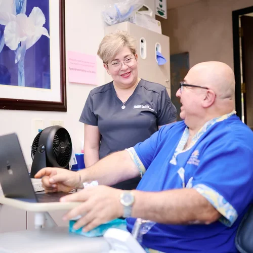 Two dental practitioners collaborating over a computer
