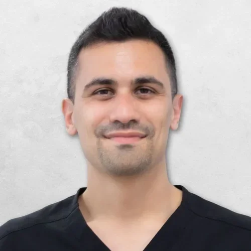 Giuseppe Carvelli is wearing black scrubs and has short black hair