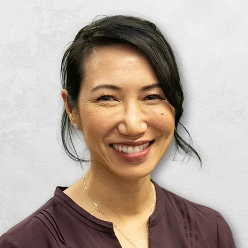 Dr. Helene Shen is wearing a dark brown V-neck blouse.