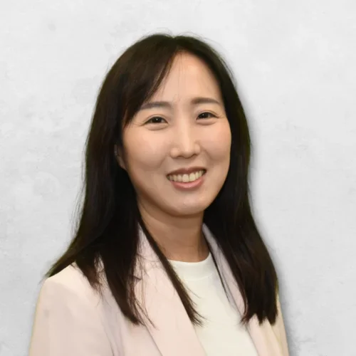 Dr. Chang is wearing a light pink blazer over a white shirt.