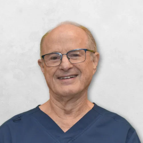 Keith L. Radack is wearing glasses and a blue scrub top. 